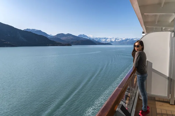알래스카 유람선은 베란다 갑판에서 산 풍경을 보고 있는 관광객들을 위해 여행을 하고 있다. 빙하만의 통로 안에서 아름다운 휴가 여성 이배에서 경치를 감상하고 있다 — 스톡 사진