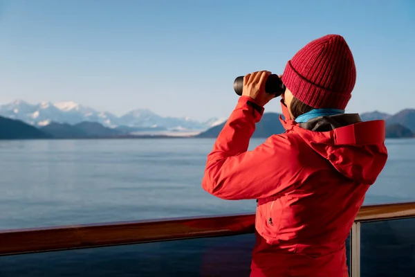 Passageiro do navio de cruzeiro Glacier Bay Alaska olhando para as montanhas do Alasca com binóculos explorando Glacier Bay National Park, EUA. Mulher em viagem Passagem interior desfrutando de vista. Aventura de férias — Fotografia de Stock