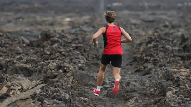 Hombre corriendo en trail runner cross-country run viviendo un estilo de vida deportivo saludable. Correr atleta masculino haciendo ejercicio como parte de un estilo de vida saludable. Vista trasera que muestra hacia atrás en Big Island, Hawaii — Vídeos de Stock