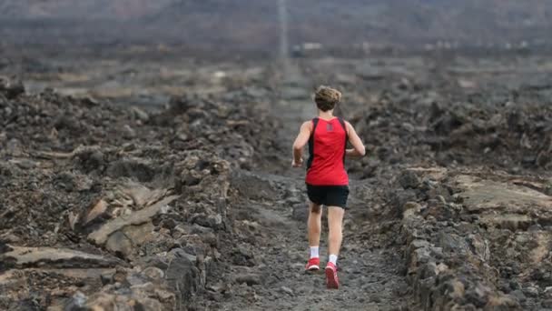Man kör - trail runner utbildning på fantastisk lava vakna spår på Hawaii utbildning för maraton eller triathlon järnmannen. Manlig idrottsman tränar på Big Island, USA. SLOW MOTION 59.94 FPS — Stockvideo