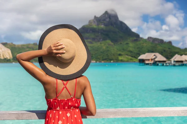 Vacaciones de playa mujer turística que mira a la vista del monte Otemanu en Bora Bora isla turística de lujo en vacaciones de viaje escapada romántica. Turismo celebración sombrero por detrás disfrutando de vacaciones de verano — Foto de Stock