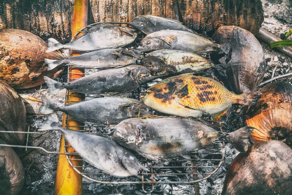 Ikan polinesia bbq adalah makanan tradisional Polinesia Prancis di pantai - perjalanan wisata piknik motu luau di Fakarava, Tahiti, Polinesia Prancis. Ikan panggang pada arang kelapa dan kayu palem barbekyu — Stok Foto
