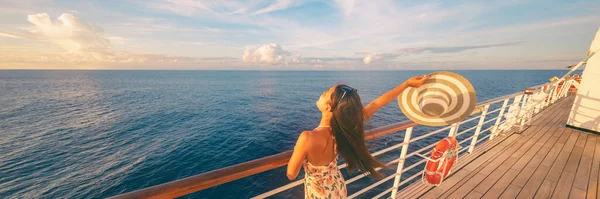 Happy cruise woman relaxing on deck feeling free watching sunset from ship on Caribbean travel vacation. Panoramic banner of sea and boat — Stock Photo, Image