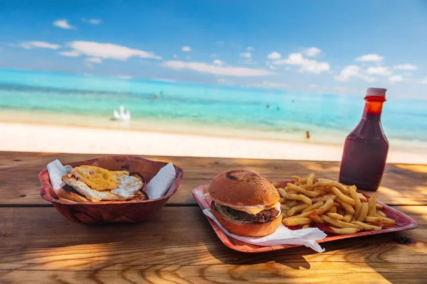 Beach fast food restaurant shake shack bar view of burger and french fries on table with view of ocean in Bora Bora, Tahiti. Polynesia island travel