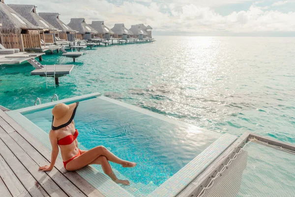 Πολυτελείς ταξιδιωτικές διακοπές σε Bora Bora high end θέρετρο ξενοδοχείο τουριστική κυρία μαυρίσματος στο μπικίνι από την πισίνα στο overwater βίλα σουίτα — Φωτογραφία Αρχείου