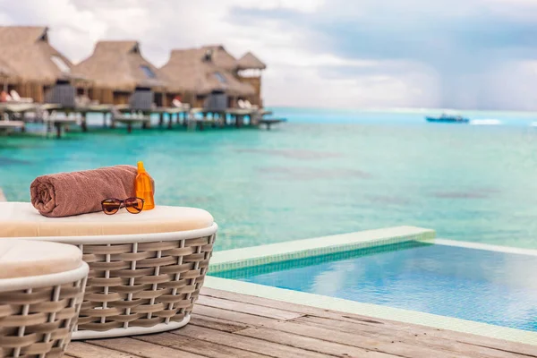 Lüks Bora Bora Bora deniz aşırı bungalov villaları. Fransız Polyneisa, Tahiti 'de lüks bir otel. Okyanus manzaralı yaz gezisi tatil beldesi arka planı, güneş kremi, havlu ve güneş gözlüğü. — Stok fotoğraf
