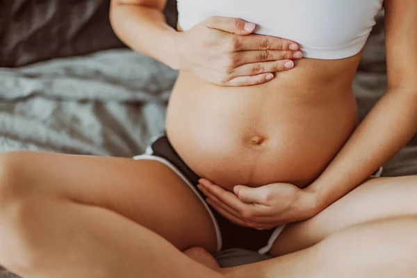 Zwangerschap buik striae en linea nigra. Zwangere vrouw strelen houden maag tijdens het eerste trimester. Gezondheidsconcept voor huidverzorging — Stockfoto