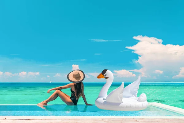 Luxusní bazén dovolená cestování dáma slunce opalování relaxační na nekonečnu oceánu nábřeží resort s plovoucí bílá labuť nafukovací hračka float prapor panoramatické letní pozadí — Stock fotografie
