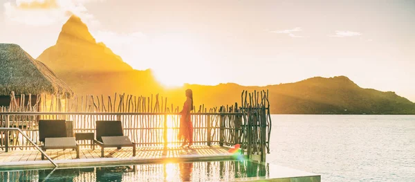 Luxury travel vacation resort. High end hotel rich people lifestyle woman tourist relaxing watching sunset on private balcony terrace of overwater bungalow suite in Bora Bora, Tahiti, French Polynesia — Stock Photo, Image