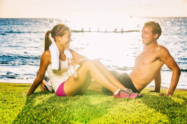 Gente sana en forma pareja entrenando juntos felices en verano al aire libre al atardecer playa fondo. Sonriendo a los jóvenes Mujer asiática Caucásico hombre relajarse después del entrenamiento de la pareja — Foto de Stock