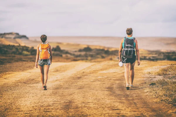 Senderismo personas caminando por senderos del desierto sendero con mochilas en la naturaleza paisaje de montaña. Senderistas aventura viajes vacaciones de verano — Foto de Stock