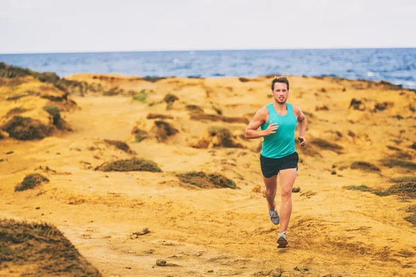 Hombre corriendo atleta corredor masculino cruzar el país corriendo en la costa de arena dorada por el océano. Jóvenes corriendo entrenando en senderos al aire libre —  Fotos de Stock