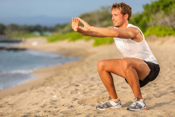 Trening fitness pasuje do człowieka trening siłowy robi przysiady na plaży. Ćwiczenia dolnej części ciała sportowiec — Zdjęcie stockowe