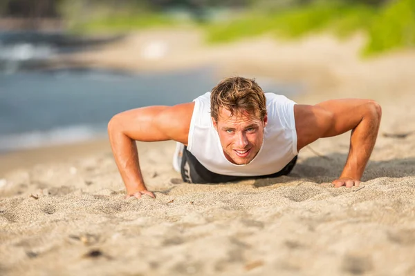 Fit man athlete training hard doing push-ups on beach. Fitness motivation Stock Photo