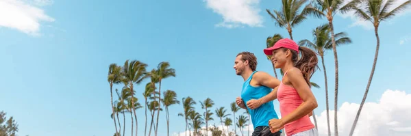 Спортсмены-бегуны пара бегуны ландшафтный баннер. Фитнес люди пара бег вместе в летнем парке на открытом воздухе. Горизонтальные пальмы фон. Азиатка, кавказский друг — стоковое фото