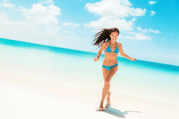 楽しいビーチカリブ海の旅行先から青いビキニで走って笑っているアジアの女性。夏休みを楽しむスリムなボディモデル — ストック写真