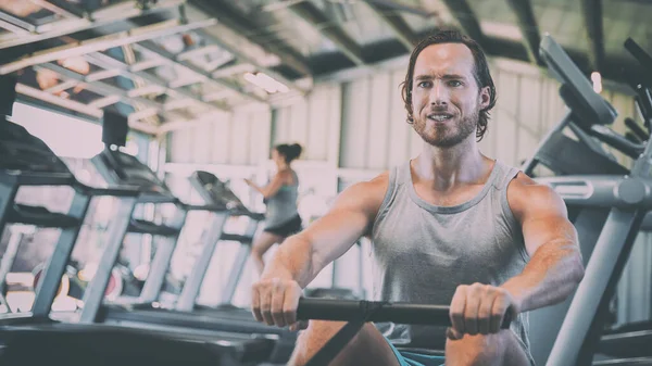 Fitness man training on rowing machine at gym