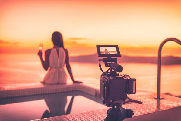 サンセットビーチリゾートホテルで女優の女性が演技、豪華な旅行を撮影シーンビデオカメラ撮影映画の背後にあるビデオ。夕暮れ時に屋外で撮影するプロのビデオ機器. — ストック写真