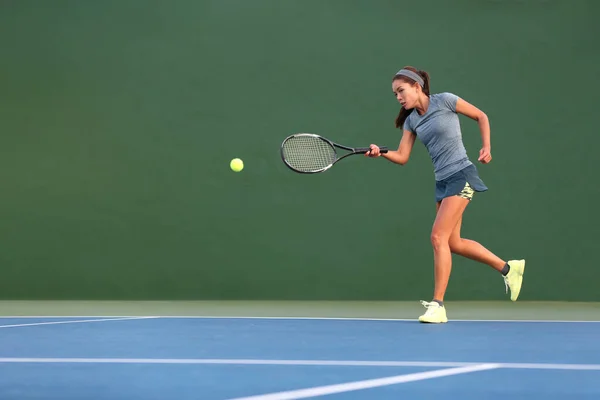 Tennisspillerbanneret slår ball med racketen på grønn, horisontal kopieringsbakgrunn. Idrettstrening på forhåndsgrep på utebane – stockfoto