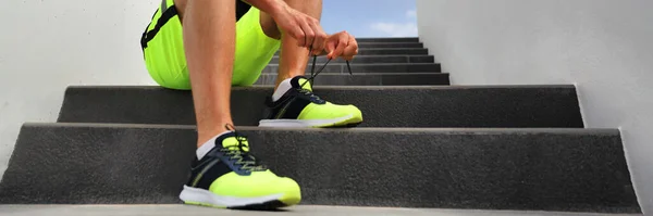 Futó férfi futócipőfűzőt kötött, hogy zászlót tegyen a városi lépcsőre. Egészséges aktív életmód sportoló jogging header panoráma termés — Stock Fotó