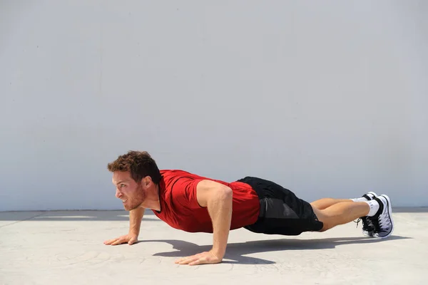 Pushup fitness człowiek robi push-up ciała ćwiczenia na podłodze siłowni. Sportowiec ćwiczący mięśnie klatki piersiowej trening siłowy na świeżym powietrzu — Zdjęcie stockowe