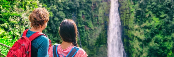 Hawaii viagens turistas na natureza cachoeira bandeira paisagem panorâmica. Casal de viajantes olhando para Akaka Falls em Big Island, Hawaiian famosa atração, EUA — Fotografia de Stock