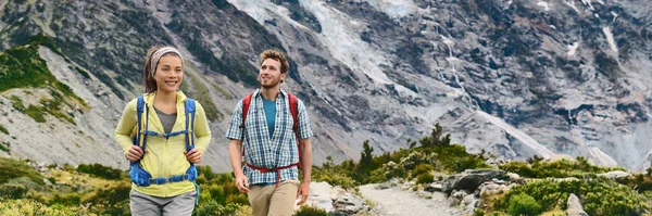 Caminhadas de viagem na Nova Zelândia Caminhantes mochileiros caminhando em montanhas paisagem natural, bandeira panorâmica. Pessoas casal turistas no verão ao ar livre caminhada — Fotografia de Stock