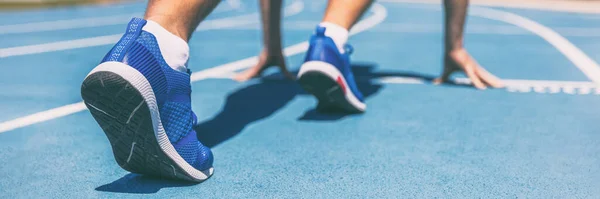 Sprinter warten auf Laufstrecken am Freiluftstadion auf den Start des Rennens Sport- und Fitnessläufer auf blauer Laufbahn mit Laufschuhen. Banner panorama. — Stockfoto