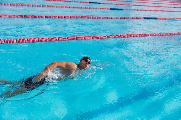 Nadar atleta deporte nadador nadando en el entrenamiento de la piscina para la carrera. Profesional de deportes acuáticos masculinos adulto haciendo ejercicio cardiovascular en el agua en el gimnasio al aire libre —  Fotos de Stock