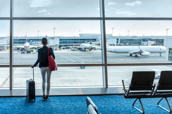 Travel tourist woman with luggage at airport — ストック写真