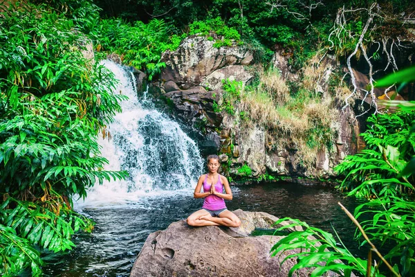 Ustupující žena jógy, modlící se při lotosu, představuje meditaci u vodopádového lesa na Kauai na Havaji. Duchovní dívka medituje v poklidné vyrovnanosti přírody. Tropická destinace cestování — Stock fotografie