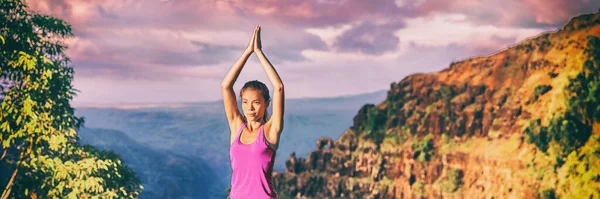 Rekolekcje jogi w Kauai natury panoramiczny sztandar. Azji dziewczyna praktykuje medytację na zewnątrz w zachód słońca siedzi z modląc się ręce nad głową dla drzewa pozować — Zdjęcie stockowe