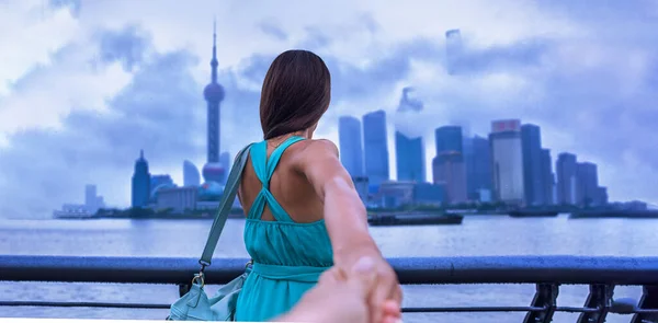 Folgen Sie mir auf Reisen in Shanghai City, China. Mann macht Selfie mit seiner Hand, die seine Freundinnen in Richtung der Skyline von Bund mit wolkenverhangenem Himmel hält. Unwetternacht. — Stockfoto