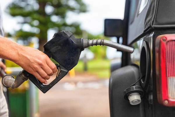 Bomba de gasolinera. Hombre llenando combustible de gasolina en la boquilla de retención del coche. De cerca. — Foto de Stock