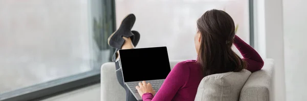Student zu Hause Remote-Arbeit beobachten Online-Klasse virtuelle Webinar Videocall. Frau von hinten entspannt Füße oben auf Sofa im Wohnzimmer, einfache Lernvideos schwarzen Bildschirm für Kopierraum. Bannerpanorama. — Stockfoto