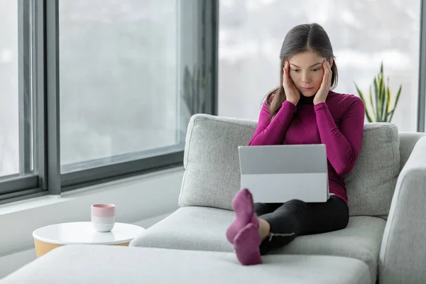 Datorproblem bärbar dator inte arbetar hemma frustrerad asiatisk kvinna med huvudvärk försöker förstå online-arbete eller fråga. — Stockfoto