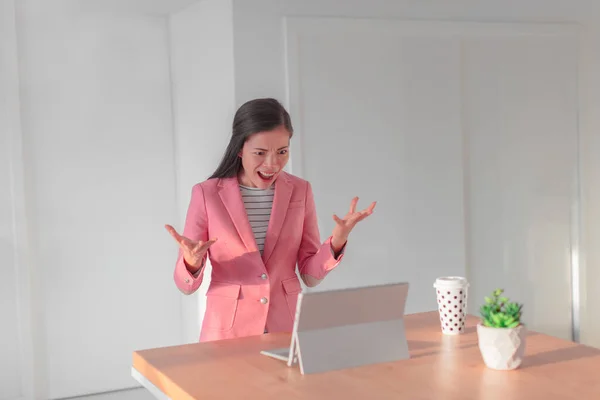 Mujer de negocios enojado con mala conexión a Internet que trabaja en el ordenador portátil desde casa durante videocall en línea con colegas de trabajo. Asiática mujer de negocios gritando molesto de rabia. — Foto de Stock