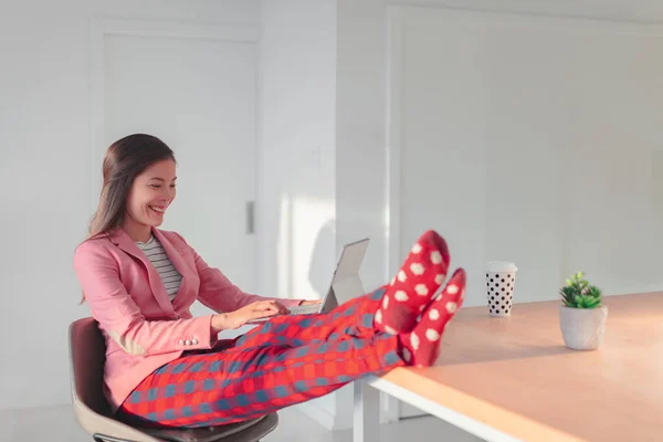 Arbeiten Sie online fernab von zu Hause lustiges Konzept. Asiatin entspannt in Pyjama-Hosen und kuscheligen Socken, während sie professionelles Top und Anzug für Videocall-Treffen trägt. — Stockfoto