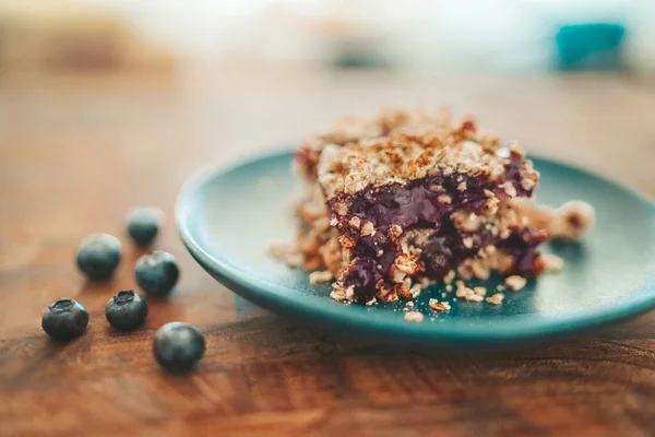 Blåbär smulas sönder söta frukter och havre krispig bar dessert platta hemma. — Stockfoto