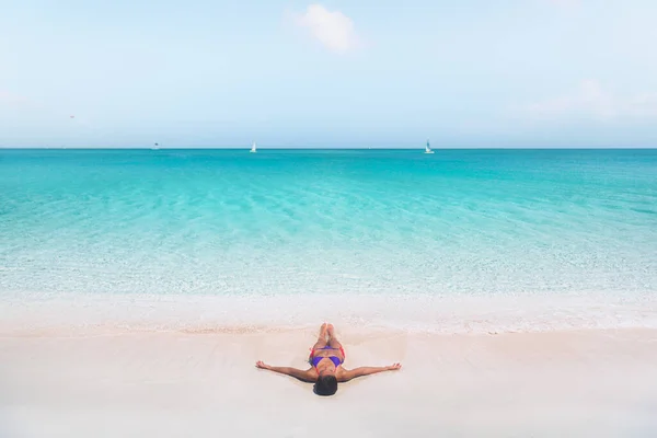 Plage vacances rêve Caraïbes destination de voyage bikini femme bronzage détente couché sur le rivage. vue de drone des vagues bleues de l'eau cristalline idyllique de l'océan lavant au-dessus — Photo