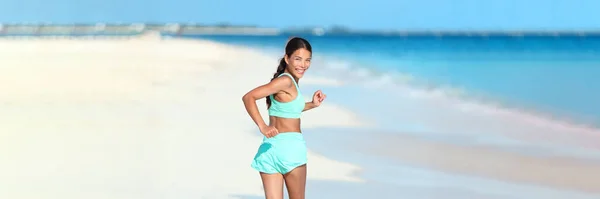 Happy running fitness girl looking back smiling on beach run jogging active healthy lifestyle. Asian woman athlete exercising cardio working out in summer outdoors — стоковое фото