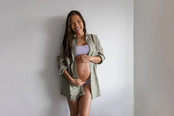 Happy Asian pregnant woman portrait at home. Pregnancy maternity underwear, model wearing organic cotton clothes, loose shirt and undies clothes for comfort — Stock fotografie