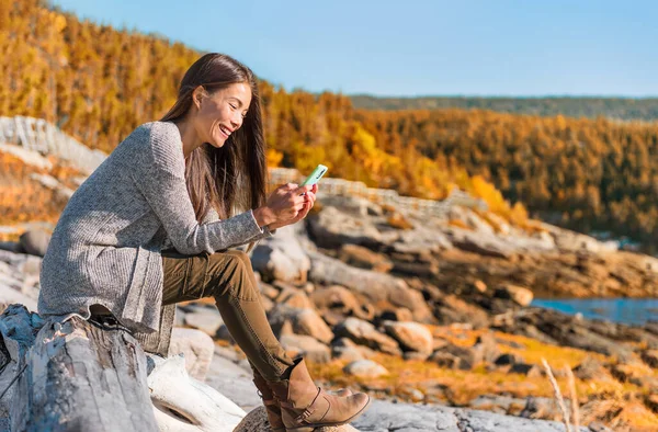 携帯電話の旅行ライフスタイル携帯電話のデータを使用してアジアの女性は カナダのケベック州の屋外ハイキングの冒険 森の紅葉の中で幸せな女の子のテキスト — ストック写真