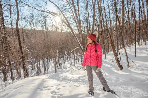 冬のスノーシューハイキング 冬の森の中でアジア系多人種の女性をスノーシューでハイキング健康的なアウトドアライフスタイルを生きるスノーシューズを身に着けて — ストック写真