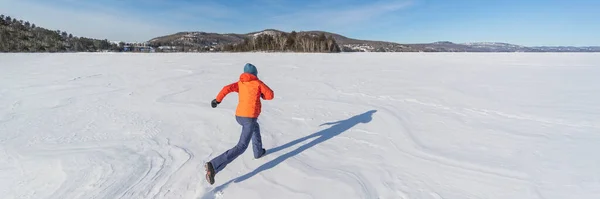 雪の多い冬の自然景観の中で凍った湖を走る女 雪の中で冬の楽しみ パノラマバナー — ストック写真