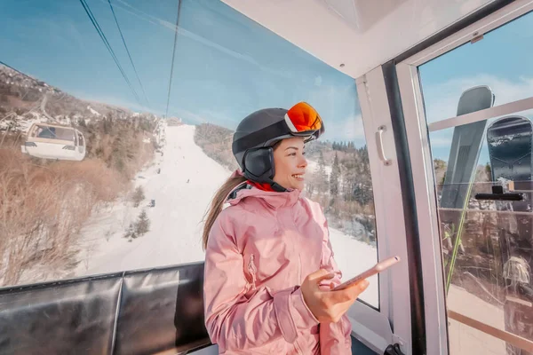 휴가철 곤돌라 리프트에서 핸드폰 사용하는 아이는 고글을 착용하고 스마트폰으로 겨울철 — 스톡 사진