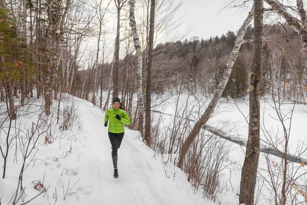 在寒冷的冬日里 在森林里 女跑步者在外面的冬雪中奔跑 将健康的生活方式理念与美丽的年轻健身模型相结合 混血的亚洲白人全身而退 — 图库照片