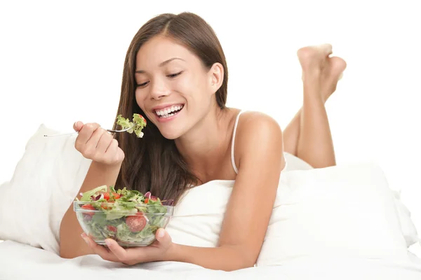 Mulher saudável comendo salada na cama — Fotografia de Stock