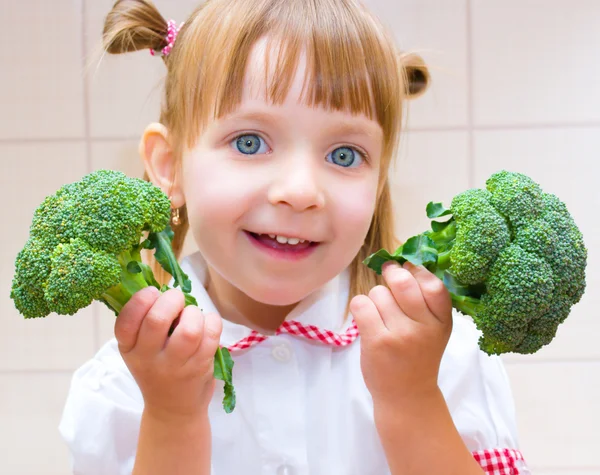 Porträtt av en liten flicka med broccoli — Stockfoto