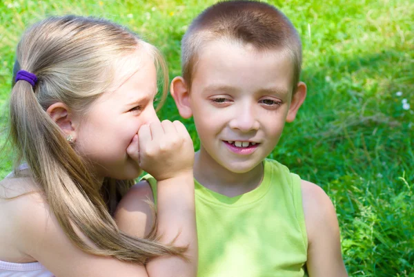 Little girl whispering something to her brother — Stock Photo, Image